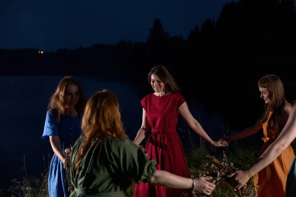 Lovely girls by the fire at night. Ancient pagan origin celebration concept. Night of Ivan Kupala.