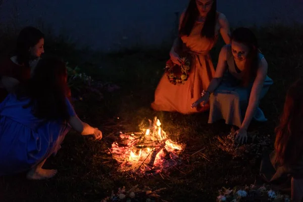 Lovely girls by the fire at night. Ancient pagan origin celebration concept. Night of Ivan Kupala.