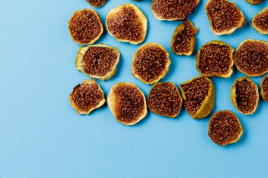 Mavi arka planda kurumuş incir dilimleri. Kurutulmuş meyve. Çevre. Üst Manzara. Pankart.