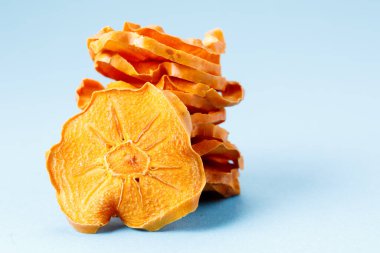 Mavi arka planda kurutulmuş hurma dilimleri. Kurutulmuş meyve. Çevre. makro.