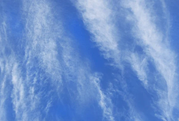 白のかすかな巻雲の雲は 深い青色の空に対して垂直方向での形成 — ストック写真