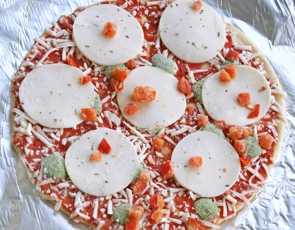 調理の準備ができてアルミ箔にモッツァレラチーズと野菜と冷凍薄い地殻ピザ — ストック写真