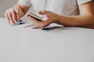 Adam renk paleti ve malzeme şablonu gözatar. Dikiş için malzeme seçimi duvar boyama için renk seçimi kavramı. Dikiş elbise, takvimler, albümler bağlama.