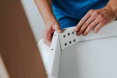 Kendinden montajlı mobilya. Adam bir parça ahşap mobilya, bir tablo, bir kabine toplanır. Bunu kendiniz evde, DIY. Adam açı tahta Ahşap toplanır. Tesisatçı'nın çalışmalarının bir önizleme.