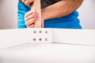 Kendinden montajlı mobilya. Adam ahşap bir mobilya parçası toplanır. Bunu kendiniz evde, DIY. Adam ahşap unsurları birleştirir. Tesisatçı'nın çalışmalarının bir önizleme.