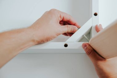 Kendinden montajlı mobilya. Adam ahşap bir mobilya parçası toplanır. Bunu kendiniz evde, DIY. Adam ahşap unsurları birleştirir. Tesisatçısı çalışma.