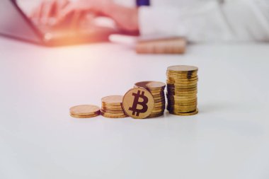 Altın sikke masanın üzerinde. Beyaz masaya vardır bitcoin altın sikke, bir adam inşaat arka planda. Cryptocurrencies üzerinde kazanç finansal büyüme kavramı bitcoin artırır.