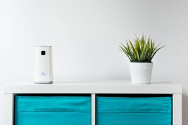 Beyaz bir arka plan üzerinde beyaz bir raf üzerinde Ionizer duruyor. İş yerinde, hava temizleme cihazı sakinleri, çalışanların ofis konforu bakımı. Toz, duman, virüs, mantar hava kurtulmak.