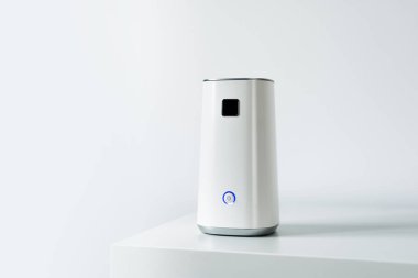 Beyaz bir arka plan üzerinde beyaz bir raf üzerinde Ionizer duruyor. İş yerinde, hava temizleme cihazı sakinleri, çalışanların ofis konforu bakımı. Toz, duman, virüs, mantar hava kurtulmak.