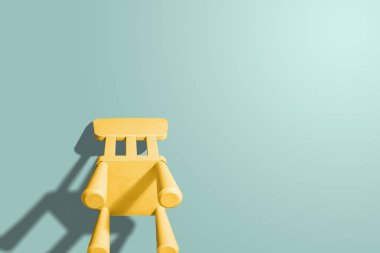 Pastel bir arka plan üzerine portakal pastel sandalye. Arka görüş. Pastel renkler. Çocuk koltuğu pastel renk. Yaratıcı kavramı, şablonları, web sitesi, yaşam tarzı. Yalnızlık.