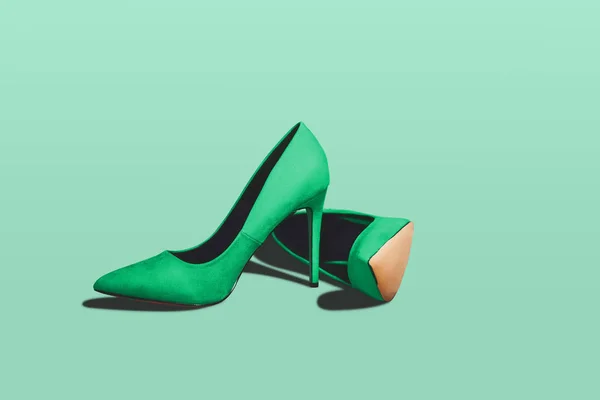 Green pastel high heels isolated on a bright green pastel background. Fashion concept, catwalk. A modern and fashionable shoe store.