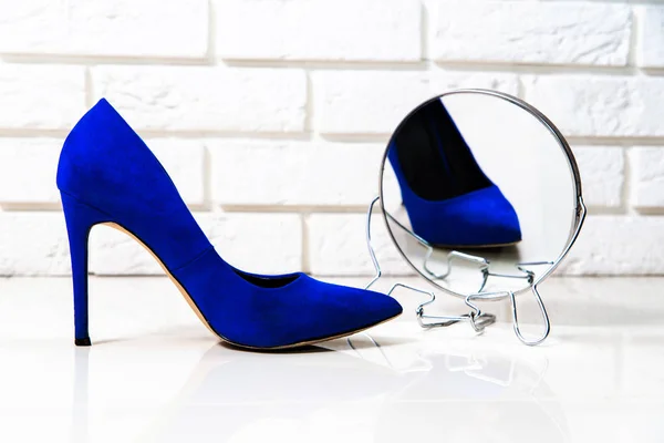 High heels purple footwear background, reflection in the mirror. Fashion concept, catwalk. Online store, fashion store, sale of shoes. The high heel lies next to the second one. Shoes for women.
