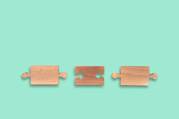 Wooden jigsaw puzzle with blank space on pastel bacgkround. There is a matching puzzle next to it. The concept of solving problems, all problems can be solved, connection.