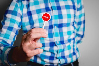 Adam dur işareti elinde tutuyor. Kırmızı bir işaret el Stop yazıt ile tutan işadamı el. İş kavramı, kötü alışkanlıklar, kesilmesi kötü faaliyetleri.