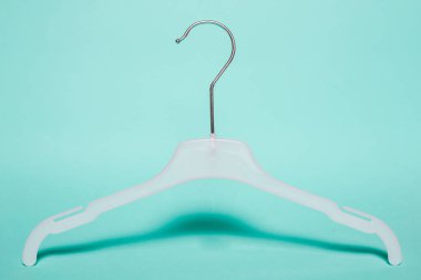 Beyaz askı pastel yeşil arka plan üzerinde elbise. Kavramı bir giyim mağazası, kıyafet depolanacağı bir yer için.