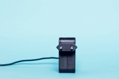 Pastel arka plan, ön görünüm üzerinde siyah güç kaynağı. Laptop, yeşil bir arka plan üzerinde elektrikli cihazlara güç için bir kablo ile siyah, büyük eklenti. Elektrik şarj konsepti.