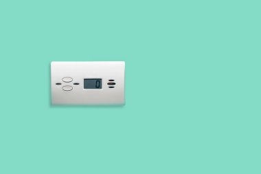 White carbon monoxide sensor mounted on the wall in the bathroom, kitchen. Caring for home security against defective gas stoves. clipart