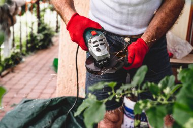 Adam bir değirmeni, kıvılcım sinek işten bıçaklı biçme'nın ile keskindir. Bir açı değirmeni netlik için kesme kullanarak. Bahçede üretim tesisi çalışır.