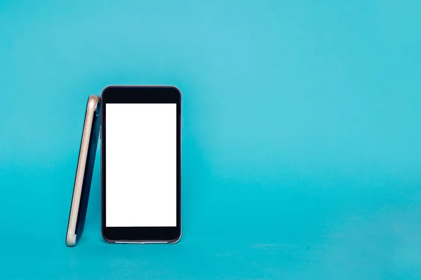 Black phone with empty display isolated on pastel background. The phone is based on a Black mobile phone with a white screen ready to be filled with content on a blue background.