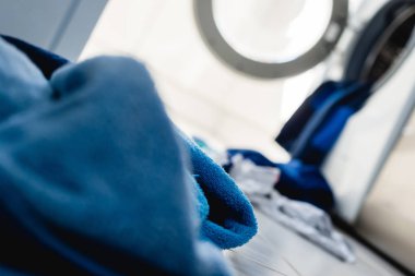 Çamaşırhane yapıyor. Dağınık kirli çamaşırları çamaşır için bir yol olarak. Giysi var olmak yıkamak istiyorum. Giyim çamaşır makinesi dışarı dökmek.