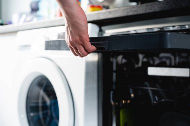 Bulaşık makinesinde bulaşık. Adam kirli bulaşık bulaşık makinesine koyar. Açılış ve kapanış bulaşık makinesi. Adam umurunda hakkında ev ödevini mu.