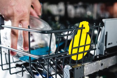 Bulaşık makinesinde bulaşık. Adam kirli bulaşık bulaşık makinesine koyar. Açılış ve kapanış bulaşık makinesi. Adam umurunda hakkında ev ödevini mu.