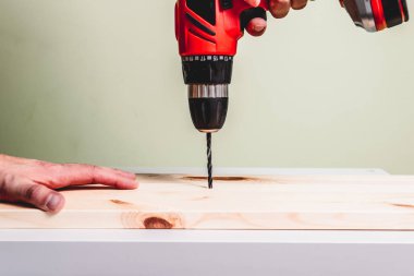 Kırmızı bir tornavida bir ahşap tahta bir delik matkap. Ahşap ürünler, el emeği kavramı yapma.