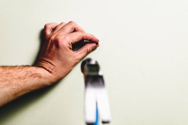Bir çivi duvar içine çekiç. Tadilat, ev kavramı. Adam mavi çekiç çivi diğer elinde tutan, elinde tutuyor. Tamirci, DIY.