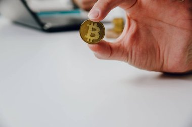 Bir adam, bir iş adamı, Bitcoin bozuk para elinde tutuyor. Büyüme ve cryptocurrencies kazanç. Adam bitcoins içinde yatırım yapmaktadır. Bitcoin para kameraya doğru döndürülüyor.