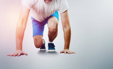 Adam bir crouch yere dokunmadan eller ile kalıyor. Yarışma için hazır başlangıç satırında crouching koşucu. Bir adam karşı parlak bir arka plan kalkışa hazır. Çalışan, koşu başladı.