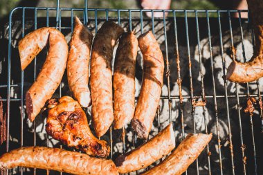 Görünümü ile sosis ızgara. Üstten görünüm pişmiş sosis. Grill'de aile ile birlikte vakit. Sosyal toplantılar, arkadaşlar. Sulu ve iyi ızgara sosis.