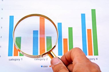 Bir istatistikte büyüteçle işaret eden adam 