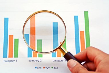 Bir istatistikte büyüteçle işaret eden adam 