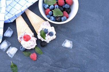  waffle dondurma konileri taze çilek ve nane koyu mermer yüzey üzerinde yatan orman meyve dondurma topları ile dolu - lezzetli meyveli dondurma ile serin bir yaz macera için kavram