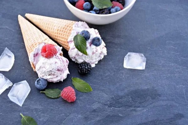 华夫饼冰淇淋圆锥 装满森林水果冰淇淋球 新鲜浆果和薄荷躺在黑暗的大理石表面 一个凉爽的夏季冒险与美味的水果冰淇淋 — 图库照片