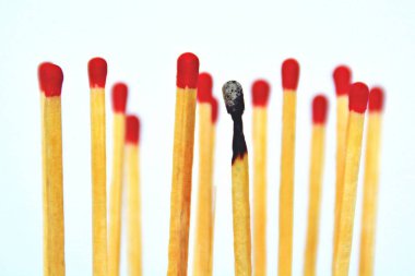 Yanmış bir maç beyaz bir arka plan karşı duruyor, yanında ve arkasında kırmızı kafaları ile bozulmamış maçlar vardır. Tükenmişlik ve tükenme kavramı