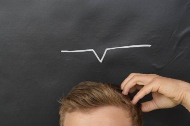 üzerinde bir sgn çizilmiş bir tahta önünde baş