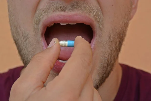 man eating pill close up of mouth