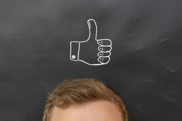 head in front of a board with drawn thumb up