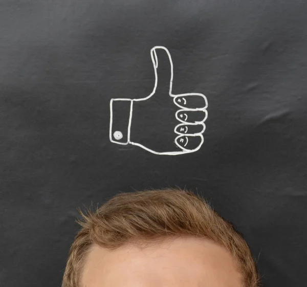 head in front of a board with drawn thumb up