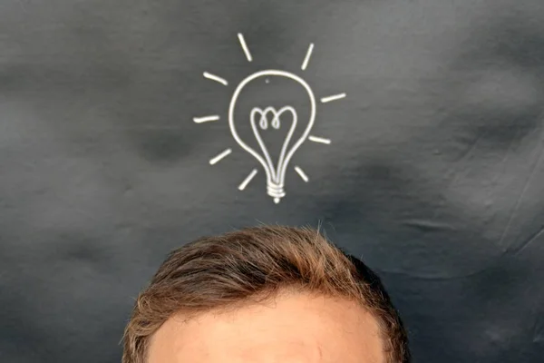 head in front of a board with a drawn lamp on