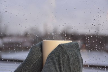 yağmurlu bir günde bir fincan çay tutmak  