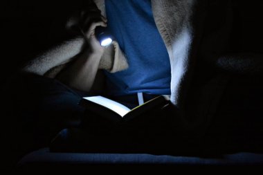 adam karanlıkta okuyor