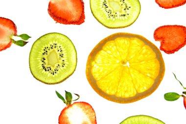 Portakal, çilek ve kivi gibi farklı dilimlenmiş meyveler parlak beyaz bir arka plan üzerinde yatıyor ve ışık ile yukarıdan aydınlatılır - farklı renklerde taze ve sağlıklı meyve kavramı