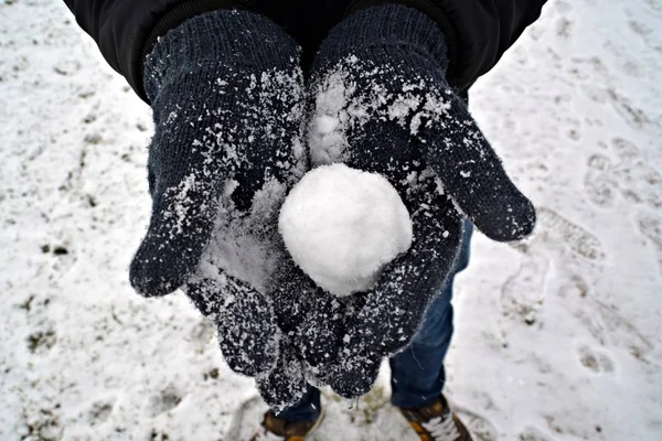 close up - form a snow ball with gloves in winter