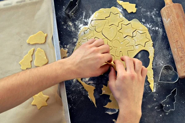 Man\'s hands baking Christmas gingerbread cookies on a table