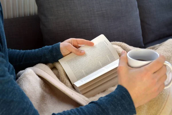 Genç Bir Adam Bir Kanepede Oturuyor Kitap Cam Bardak Çay — Stok fotoğraf