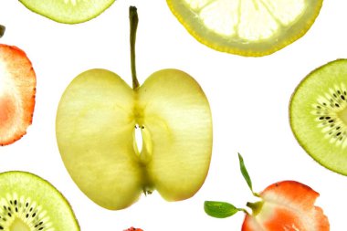 Portakal, çilek ve kivi gibi farklı dilimlenmiş meyveler parlak beyaz bir arka plan üzerinde yatıyor ve ışık ile yukarıdan aydınlatılır - farklı renklerde taze ve sağlıklı meyve kavramı - 