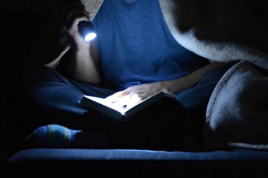 adam karanlıkta okuyor