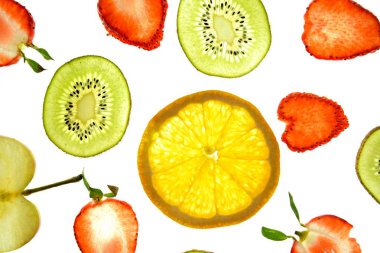 Portakal, çilek ve kivi gibi farklı dilimlenmiş meyveler parlak beyaz bir arka plan üzerinde yatıyor ve ışık ile yukarıdan aydınlatılır - farklı renklerde taze ve sağlıklı meyve kavramı